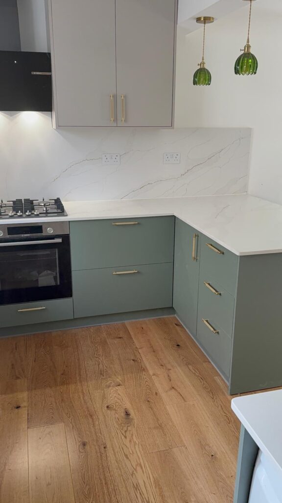 Fitted kitchen with sage green units, quartz worktop and hardwood flooring by R3 Carpentry, Acton