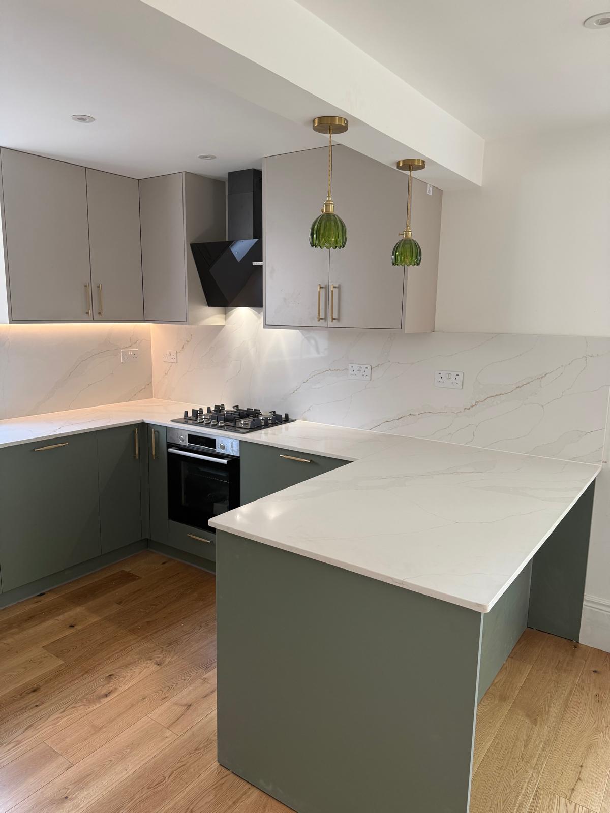 Finished sage green kitchen with brass handles and marble effect worktop