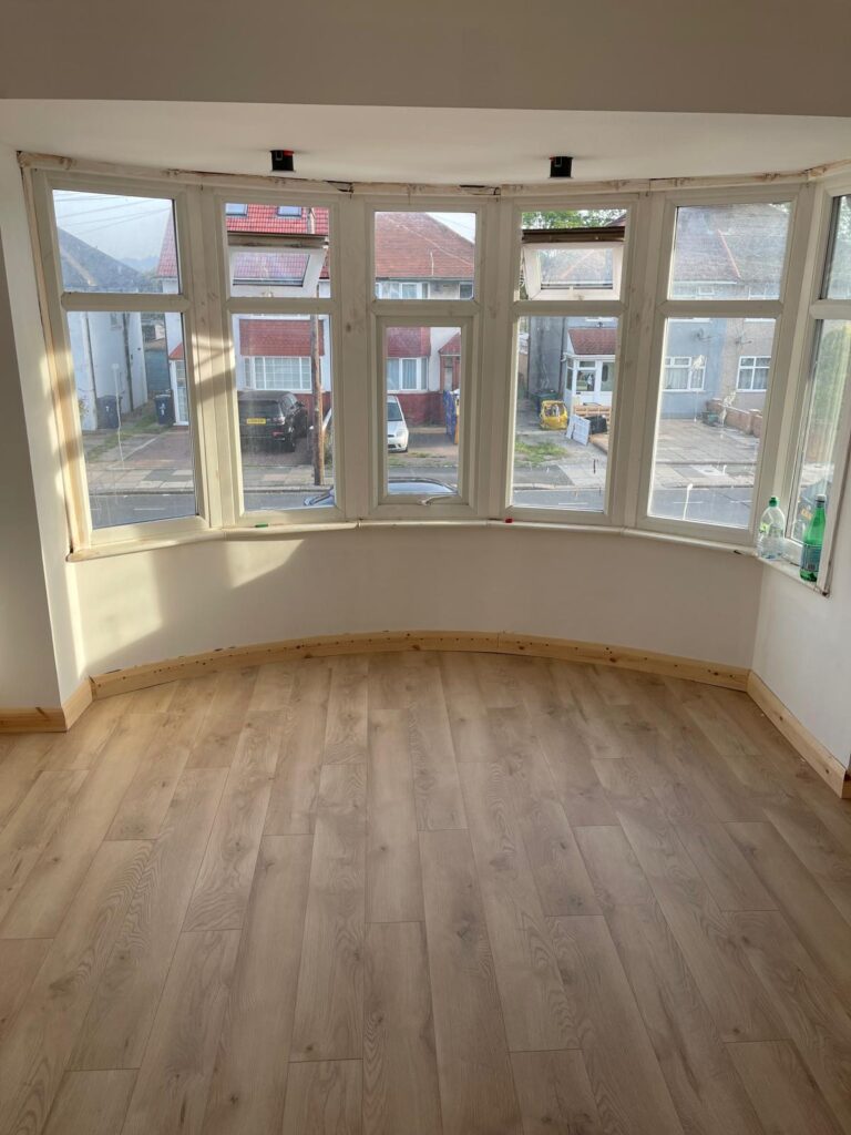 Light engineered oak flooring fitted in a bay-fronted living room in West London