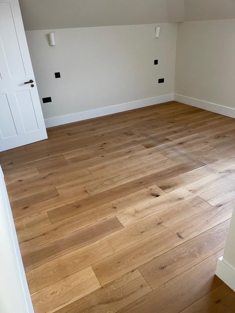 Natural oak plank flooring fitted in a bright bedroom
