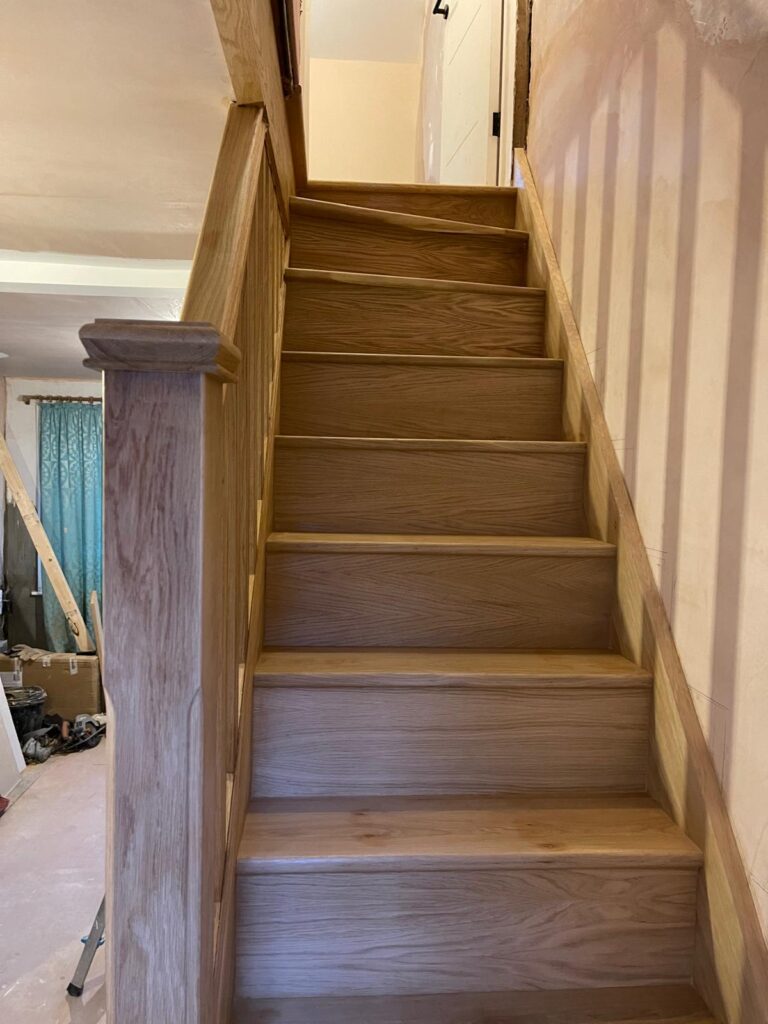 New solid oak staircase with oak treads, risers, a square newel post and winder steps, built by R3 Carpentry