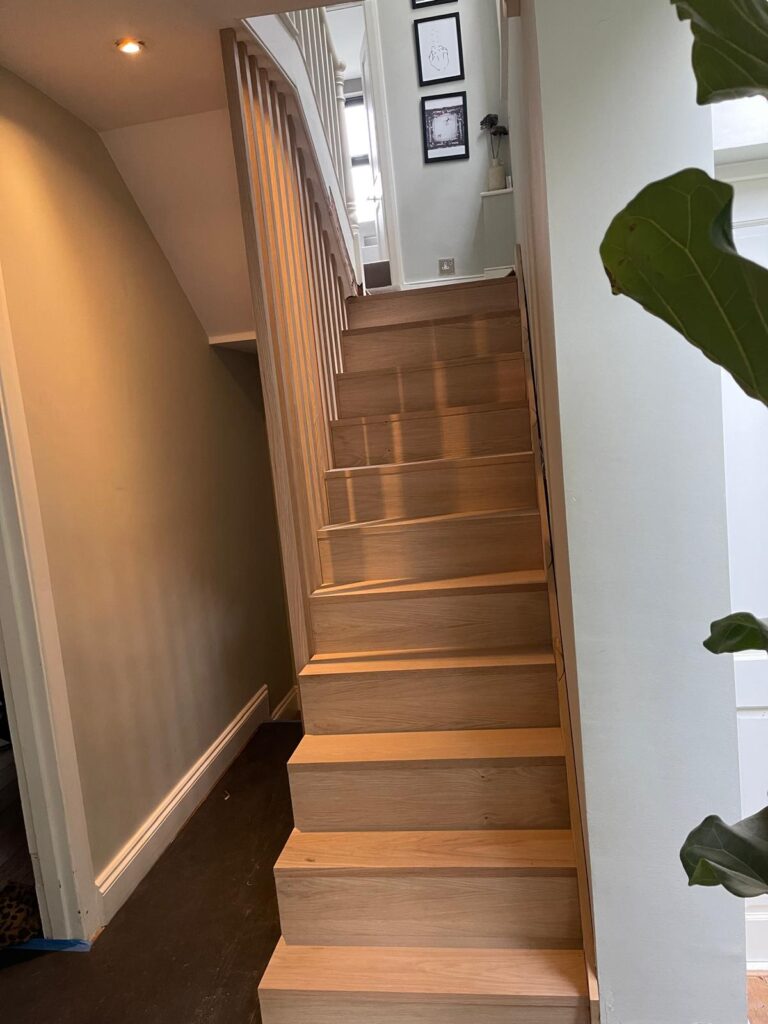Oak staircase with solid oak treads, risers and a vertical slatted oak balustrade, by R3 Carpentry